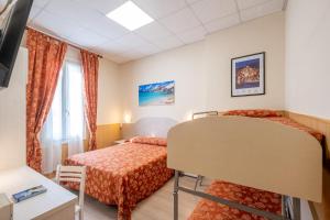 una camera d'albergo con due letti e una finestra di Hotel Corso a Sanremo