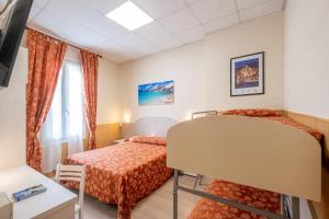 a hotel room with two beds and a window at Hotel Corso in Sanremo