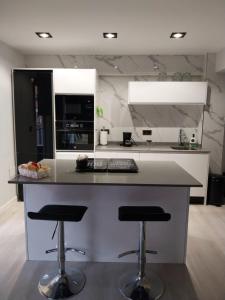 a kitchen with a counter and two bar stools at Piso deluxe centro cerca del BEC in Barakaldo