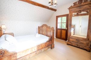 um quarto com uma cama de madeira e um espelho em Time travel em Vouvray