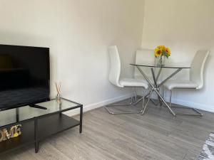 - un salon avec une table, des chaises et une télévision dans l'établissement Airport house , Speke, à Speke