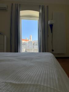 - une chambre avec un lit blanc et une fenêtre dans l'établissement Casa al porto, à Giovinazzo