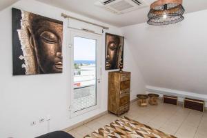 a room with a window and paintings on the wall at LA CARAMBOLE - T3 DUPLEX à Terre Sainte vue mer in Saint-Pierre
