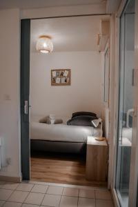 een slaapkamer met een bed in de hoek van een kamer bij St-OrensBnB - Cosi - WIFI - Parking - Terrasse in Saint-Orens-de-Gameville