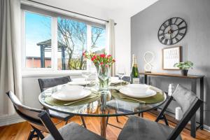 a dining room with a glass table and chairs and a window at Birmingham City Centre - 3 Bedroom House - Parking - Netflix - Wifi - Upto 7 Guests -12W in Birmingham