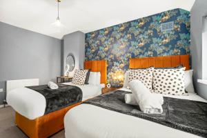 um quarto com 2 camas e um mural de parede em Birmingham City Centre - 3 Bedroom House - Parking - Netflix - Wifi - Upto 7 Guests -12W em Birmingham
