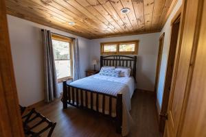 1 dormitorio con 1 cama con techo de madera en Daggett Lodge, en Warrensburg