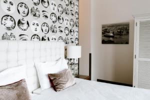 a bedroom with a white bed and a wall of faces at Hotel New York by WestCord in Rotterdam