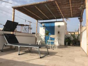 une chaise sur le toit d'une maison dans l'établissement Casita bonita de pescador parking y sabanas en opción, à Almería