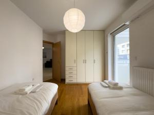 1 dormitorio con 2 camas y ventana grande en Gtrip Nea Smyrni Floor Apartment 4F, en Atenas