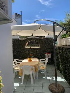 a table and chairs under an umbrella on a patio at Delizioso appartamento Girasole in Ischia