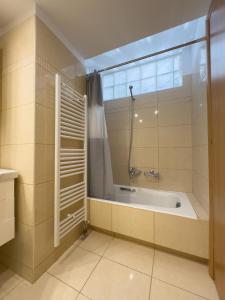 baño con bañera y ventana en Gtrip Nea Smyrni Floor Apartment 4F, en Atenas