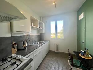 a small kitchen with a sink and a stove at Le Soleil Levant - Beau T3 moderne et lumineux in Poitiers
