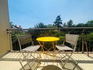 d'une table jaune et de deux chaises sur un balcon. dans l'établissement Le Soleil Levant - Beau T3 moderne et lumineux, à Poitiers