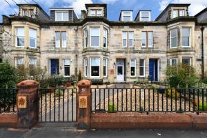 une vieille maison avec une clôture en fer devant elle dans l'établissement The Townhouse Ayr - Luxury B&B, à Ayr