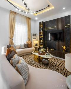 sala de estar con sofá blanco y TV en Stylish and Cozy 4 bedroom 4 bathroom Home Lekki, en Lekki