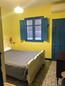 a bedroom with a bed with blue cabinets and a window at Casita bonita de pescador parking y sabanas en opción in Almería