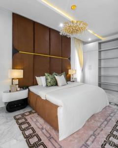 sypialnia z dużym białym łóżkiem i 2 lampami w obiekcie Stylish and Cozy 4 bedroom 4 bathroom Home Lekki w mieście Lekki