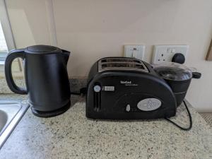 a black toaster sitting on a counter next to a coffee pot at Homely 2 bed caravan sleeps 4 5 in Portland Dorset in Portland