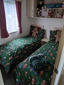 two twin beds in a room with christmas themed beds at Homely 2 bed caravan sleeps 4 5 in Portland Dorset in Portland
