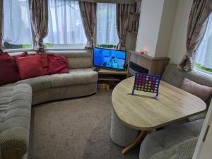 a living room with a couch and a table at Homely 2 bed caravan sleeps 4 5 in Portland Dorset in Portland