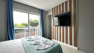 1 dormitorio con 1 cama, TV y ventana en 13- Studio Decorado Lindo! Ótimo para Casal!!!, en Curitiba