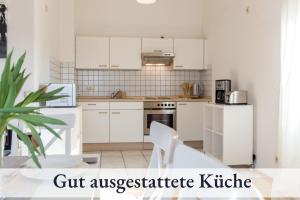 a kitchen with white cabinets and white appliances at Relax-Apartment mit Balkon, Küche und Parkplatz in Grünenbach