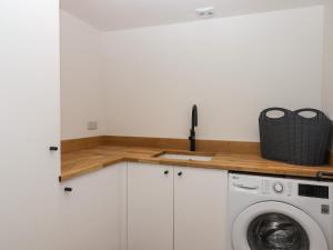 a kitchen with a washing machine and a counter at 3 Caddaford Barns in Buckfastleigh