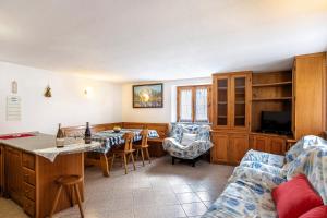 una cucina e un soggiorno con tavolo e divano di Casa Vacanza Menfrey a Verrayes