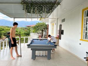 Due uomini che giocano a biliardo su un patio di Finca Vacacional el Ocaso a Rivera