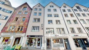 una fila de edificios blancos en una calle en Zentrale 2,5 Altstadtwohnung - Boxspringbett - Smart TV, en Chur