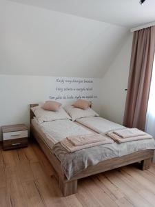 a bedroom with a bed with a quote on the wall at Pensjonat Mickiewicz in Sandomierz