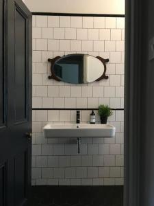 a bathroom with a sink and a mirror on the wall at BOHOUSE Moody boho townhouse Macclesfield centre in Macclesfield