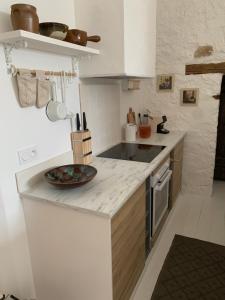 a white kitchen with a plate on the counter at Maison Le Haut Fée in Serécourt