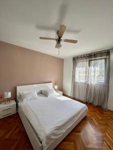 1 dormitorio con cama blanca y ventilador de techo en Apartman Split, en Split