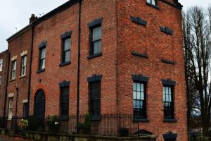 a large red brick building with black windows at BOHOUSE Moody boho townhouse Macclesfield centre in Macclesfield
