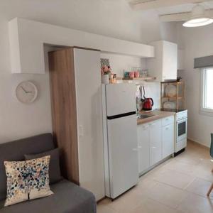 eine Küche mit einem Kühlschrank und einem Sofa in einem Zimmer in der Unterkunft Elia House 3 near Nafpaktos in Lóngos