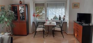 a dining room with a table and chairs and a television at Ferienwohnung an der Burg in Windeck