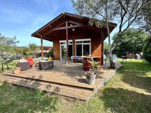 a wooden deck with a pavilion in a yard at Maison familiale en bois proche du lac de Cazaux in La Teste-de-Buch