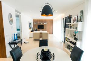 uma sala de estar com uma mesa branca e cadeiras em Casa Tranquilidade - Casa moderna com piscina em Guimarães