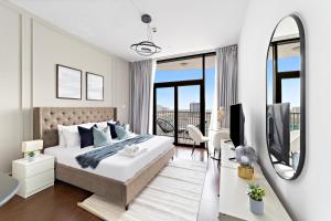 a white bedroom with a large bed and a mirror at Silkhaus Modern Luxurious Studio Near Dubai Silicon Oasis Shopping Mall in Dubai