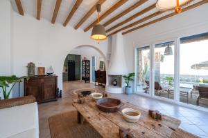 un soggiorno con tavolo in legno e una grande finestra di Villa Palm- SeaView-Hot Tub-200m from Ftelia beach a Mykonos Città Altre 29 foto