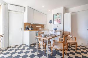 バンドールにあるStudio Damier - 3 étoiles - Welkeysのテーブルと椅子のあるキッチンとダイニングルーム