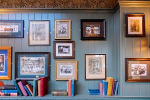 Una pared con un montón de libros y fotos en The Royal Oak en Woodford