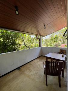 Habitación con balcón con mesa y sillas. en Tanzanite place, en Tangalle
