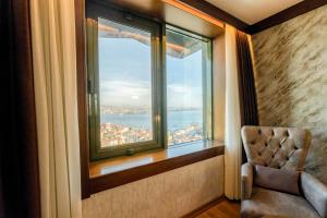 a room with a chair and a window with a view at Marble Hotel in Istanbul