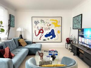 倫敦的住宿－Cozy apartment in Marylebone，客厅配有蓝色的沙发和电视