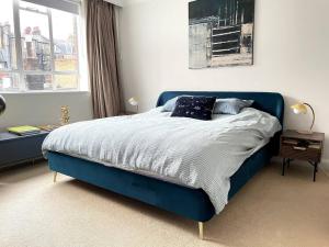 倫敦的住宿－Cozy apartment in Marylebone，卧室内的一张蓝色的床,卧室设有窗户