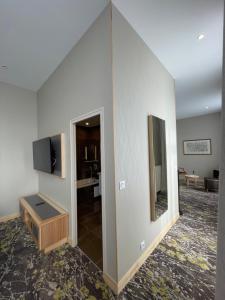 a living room with a television and a mirror at Hotel Le Cercle in Cherbourg en Cotentin