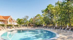 a swimming pool with chaise lounges and chairs at Résidence Pierre & Vacances Les Dunes du Médoc in Soulac-sur-Mer